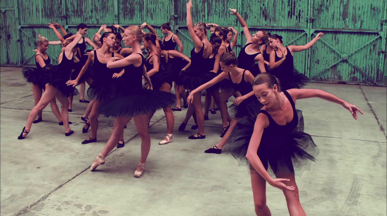 a group of young women in black dresses dancing