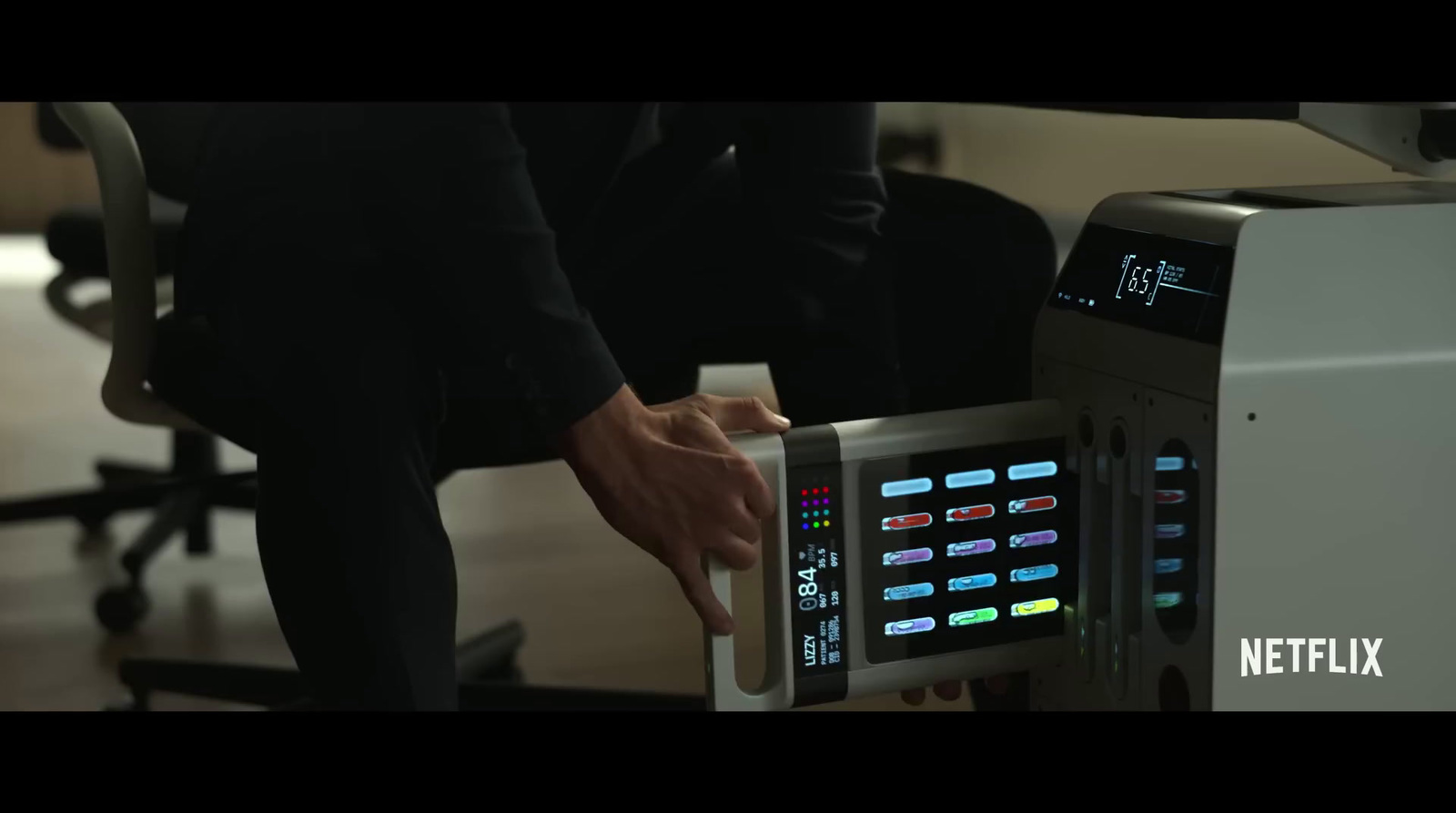 a man in a black suit is using a machine