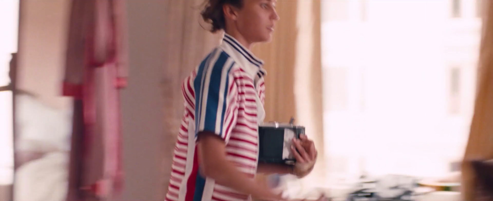 a man in a striped shirt holding a camera