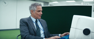 a man in a suit sitting in front of a computer