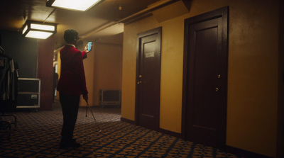 a woman standing in a hallway holding a cell phone