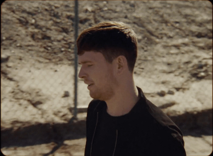 a man standing in front of a dirt hill