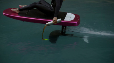 a man in a wet suit is sitting on a surfboard in the water