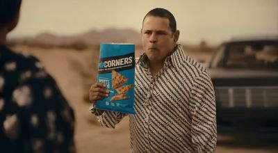 a man holding a box of corn chips