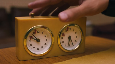 a yellow clock sitting on top of a wooden table