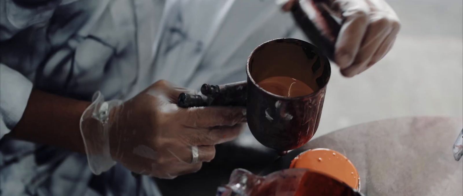 a person is pouring something into a vase