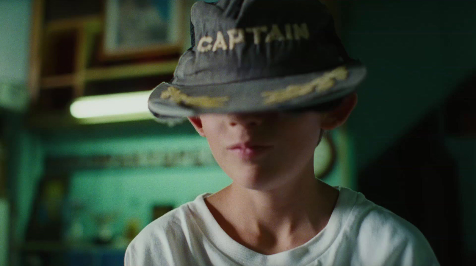 a young boy wearing a hat with the word captain on it