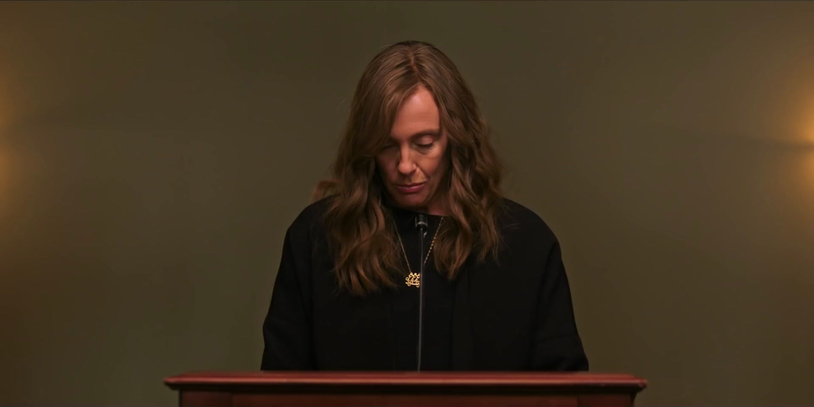 a woman standing at a podium in front of a microphone