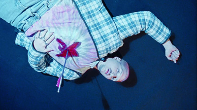 a man laying on the ground with a toothbrush in his mouth