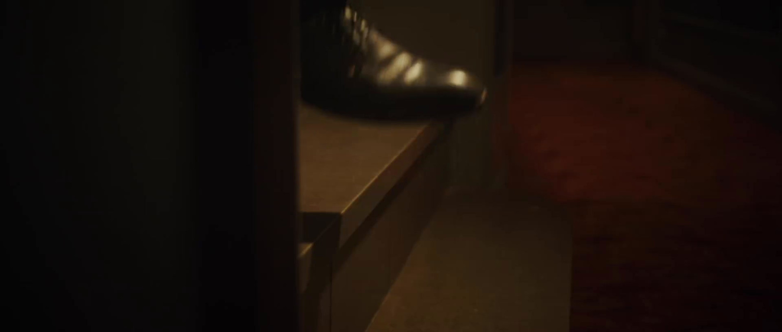 a pair of black shoes sitting on top of a wooden bench