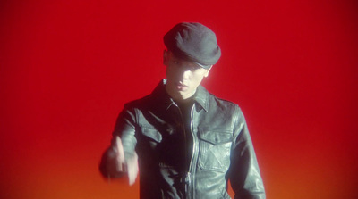 a man in a black leather jacket and hat