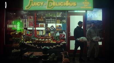 two men standing outside of a store at night