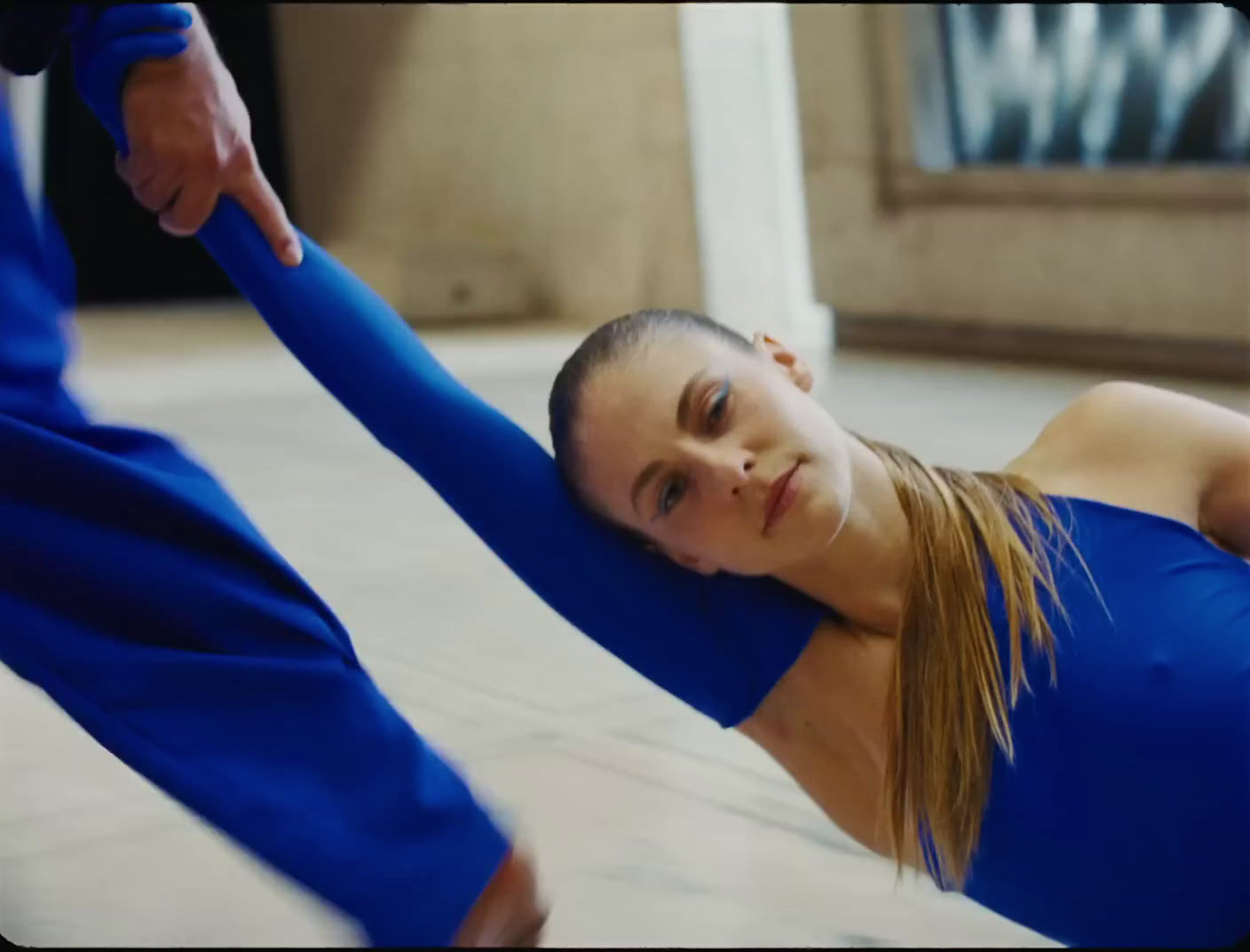 a woman in a blue top doing a yoga pose