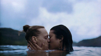 a man and a woman kissing in a body of water