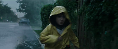 a person in a yellow raincoat walking down a street