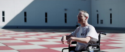 a man sitting in a wheel chair on a checkered floor