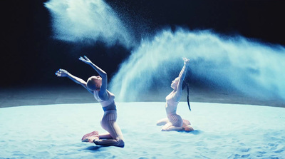 a couple of women standing on top of a snow covered ground