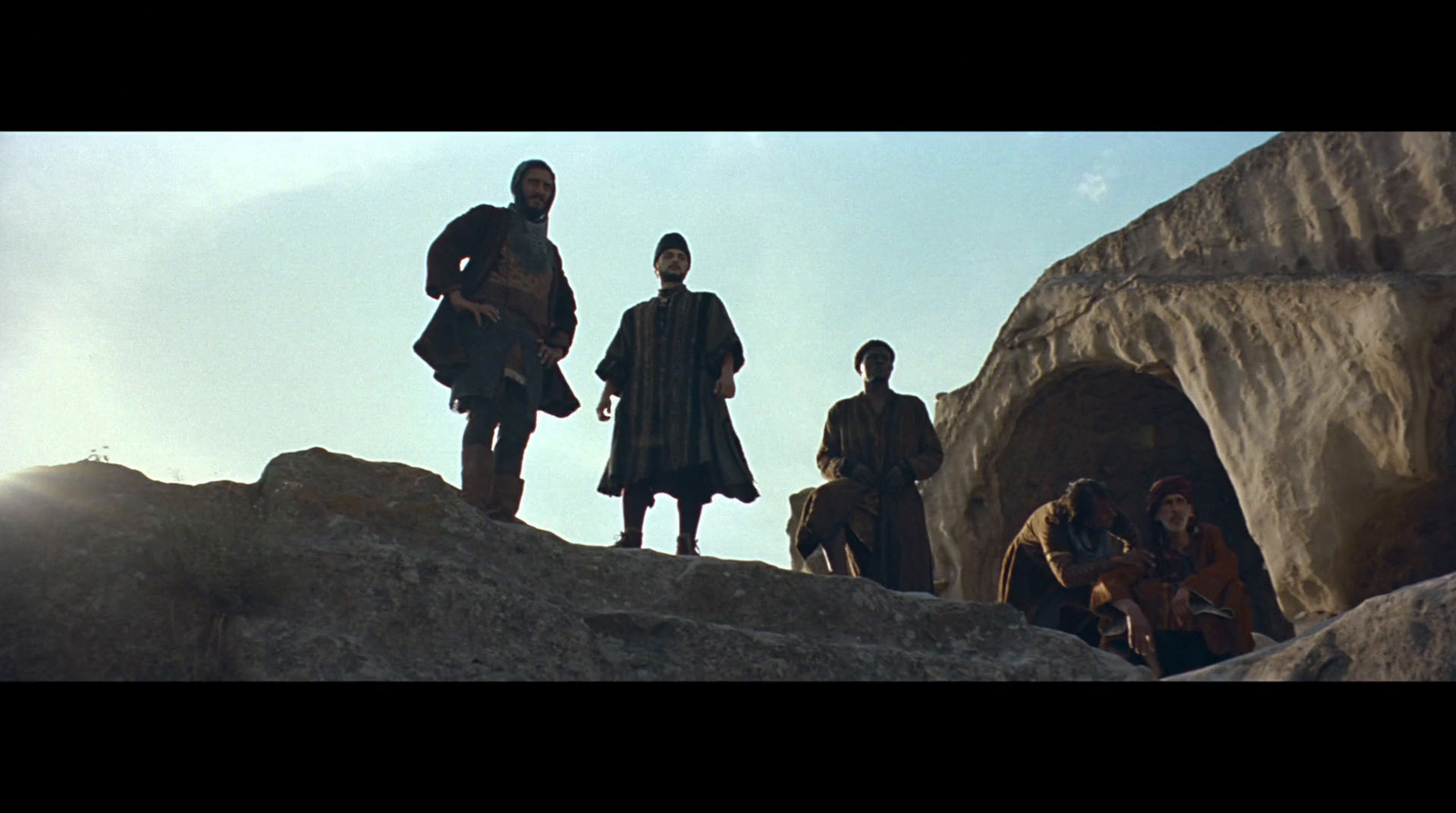 a group of people standing on top of a rocky hill