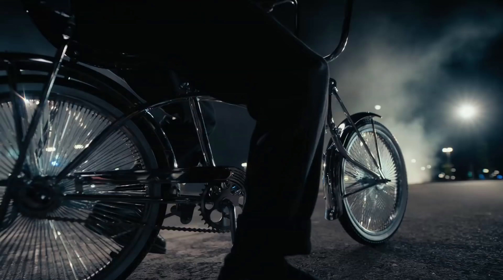 a man riding a bike down a street at night