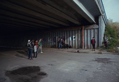 a group of people standing under a bridge