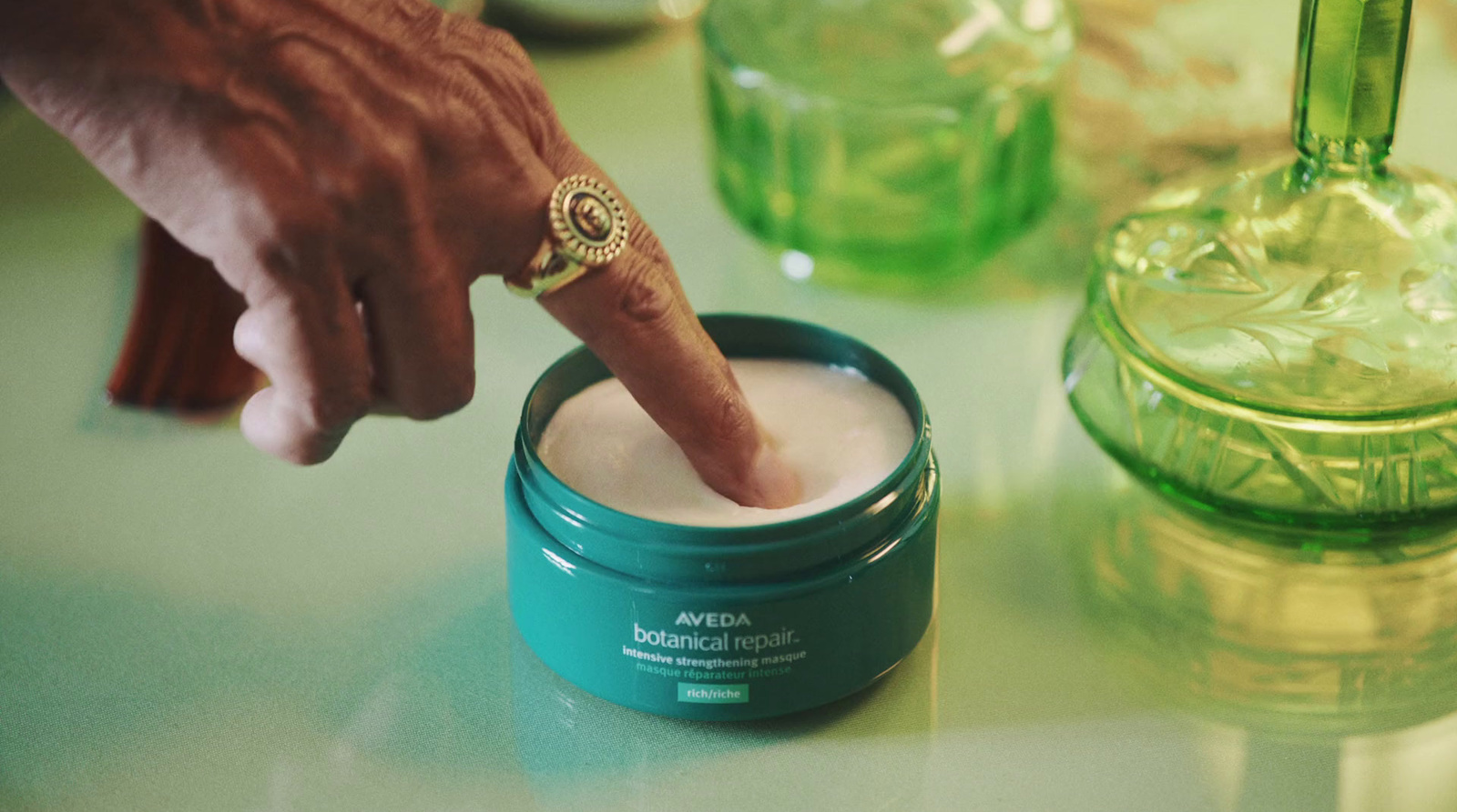 a person touching a jar of cream on a table