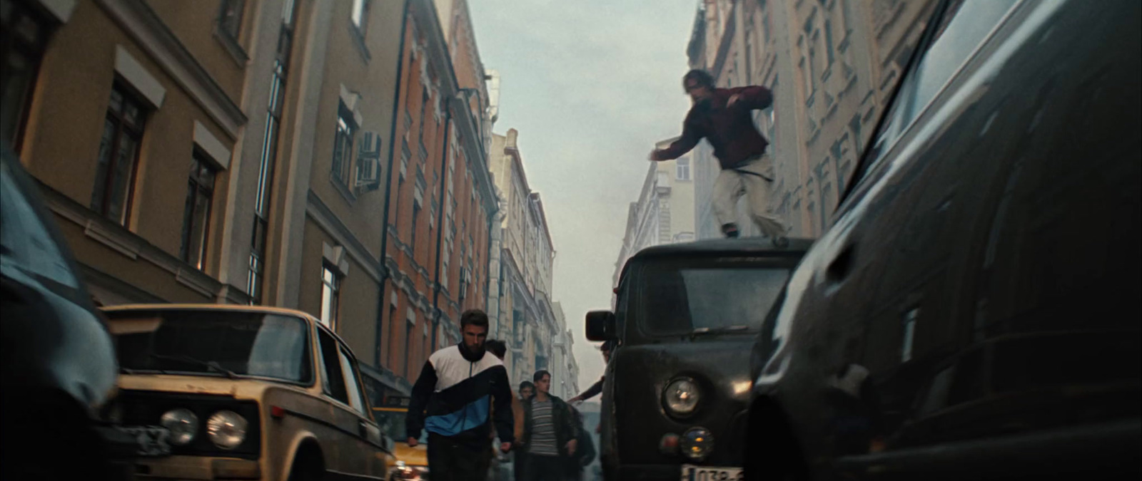 a group of people walking down a street next to tall buildings