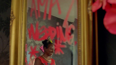 a woman standing in front of a mirror with graffiti on it