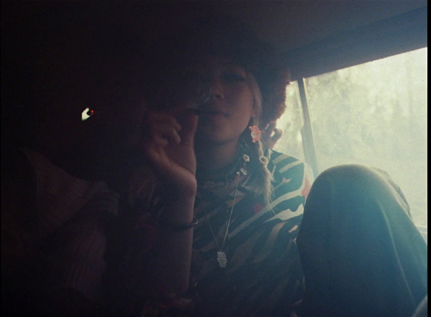 a woman sitting in a car talking on a cell phone