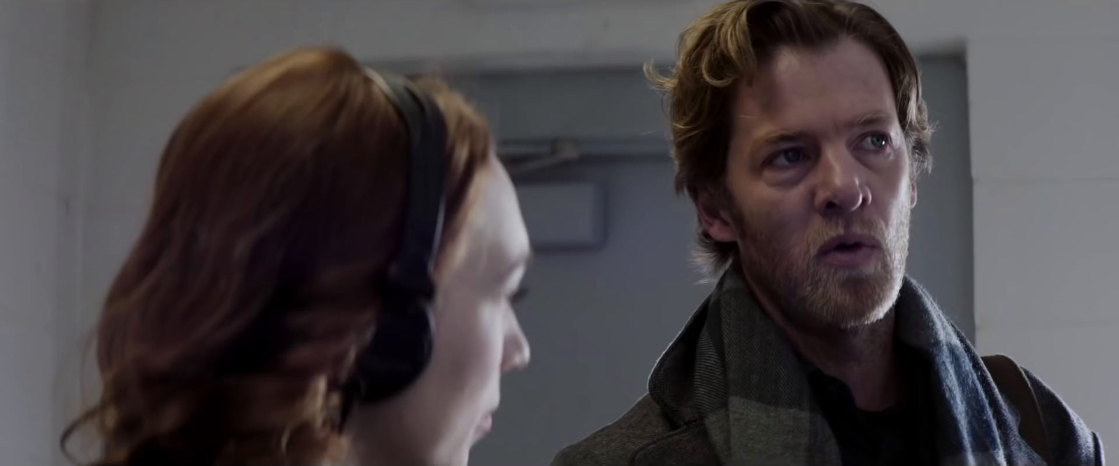 a man and a woman with ear muffs looking at each other