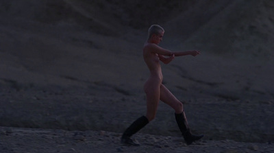 a nude woman walking on the beach at night