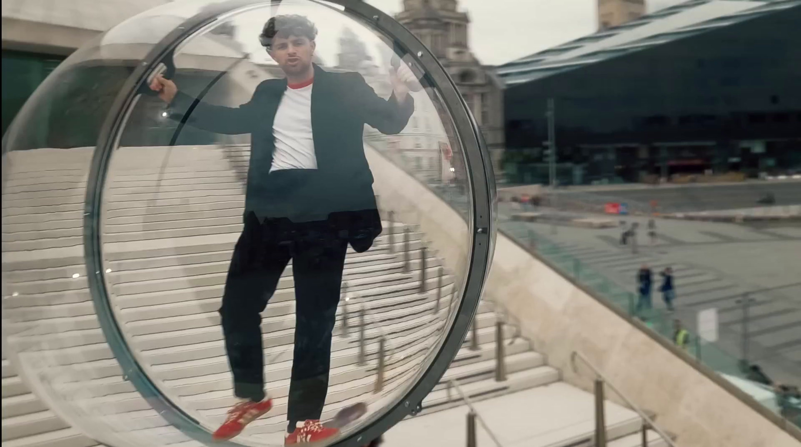 a man in a suit standing inside of a glass ball