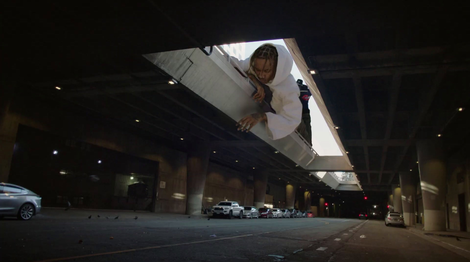 a woman in a white shirt and black tie standing under a bridge