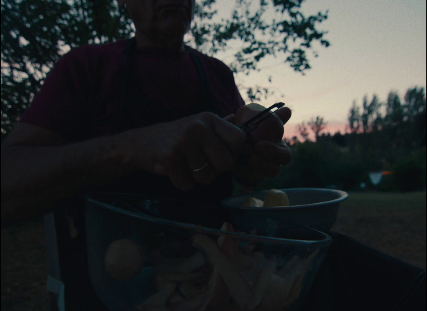 a man holding a cell phone in a bowl of food