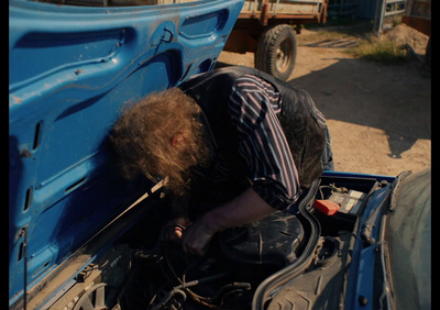 a man with a beard is bent over in the back of a truck