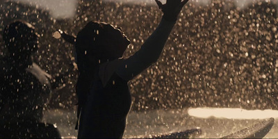 a person standing in the rain with their arms up