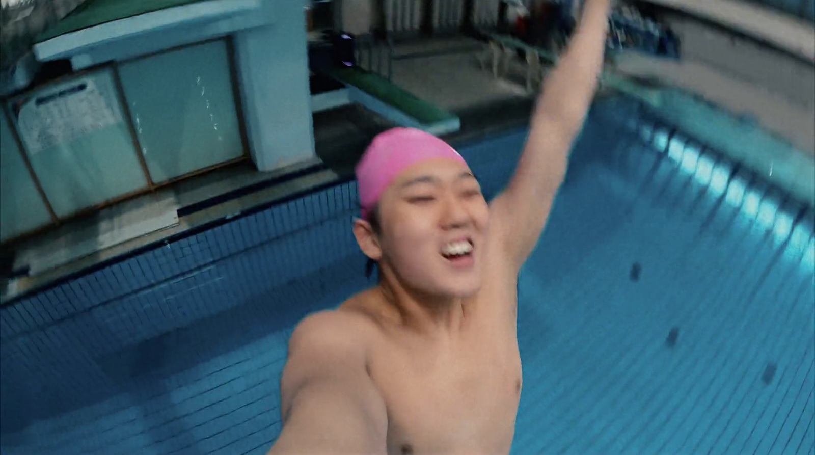 a man in a swimming pool wearing a pink hat