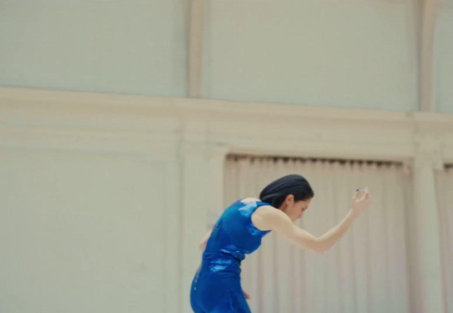 a woman in a blue dress playing a game of frisbee