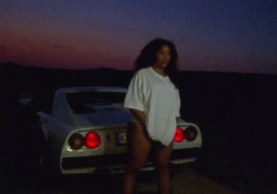 a woman standing in front of a white car