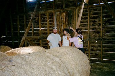 a group of people standing around a pile of hay