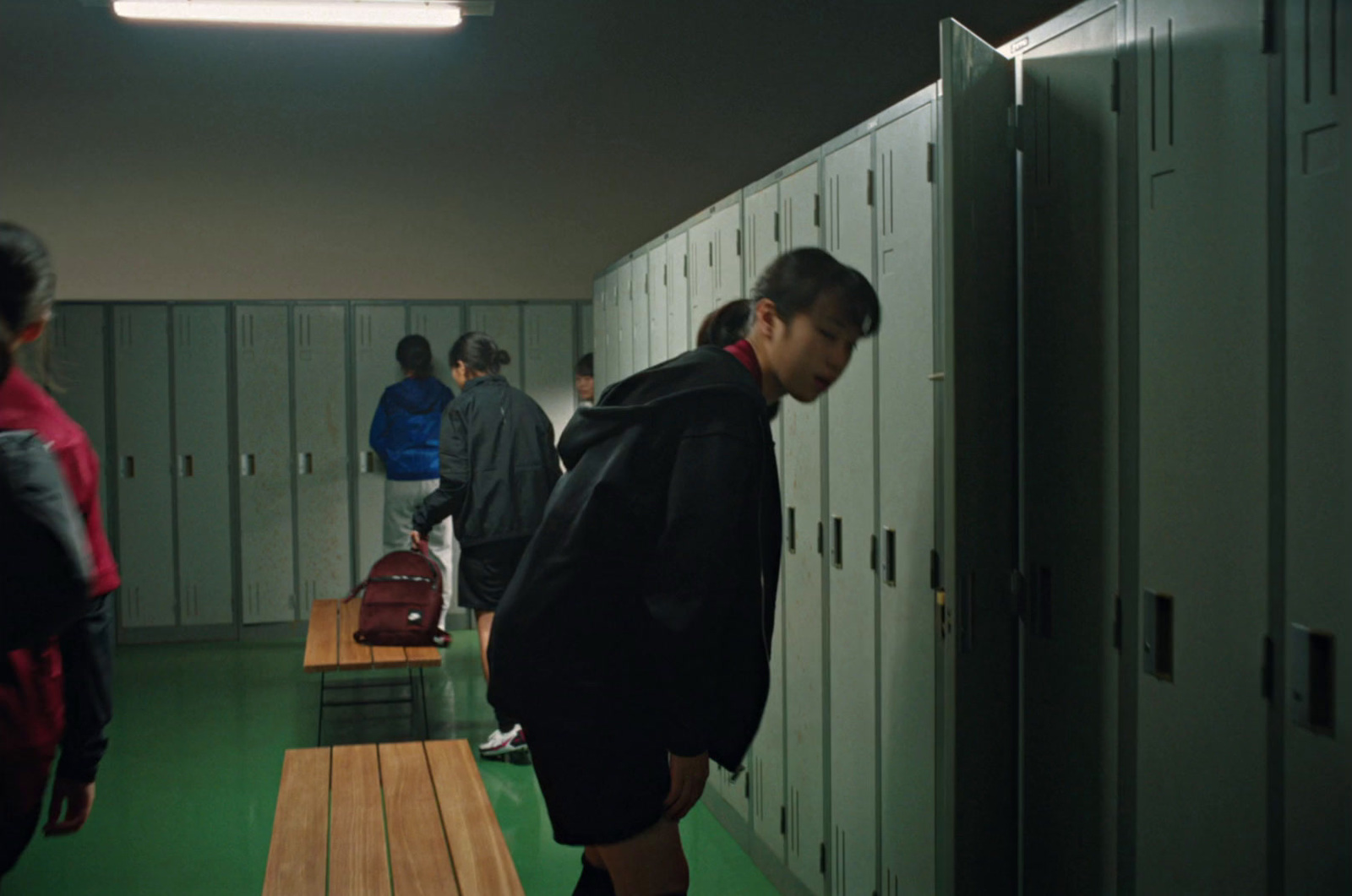 a group of people standing in a hallway next to lockers