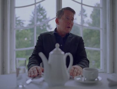 a man sitting at a table in front of a teapot