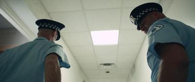 a couple of men standing next to each other in a hallway