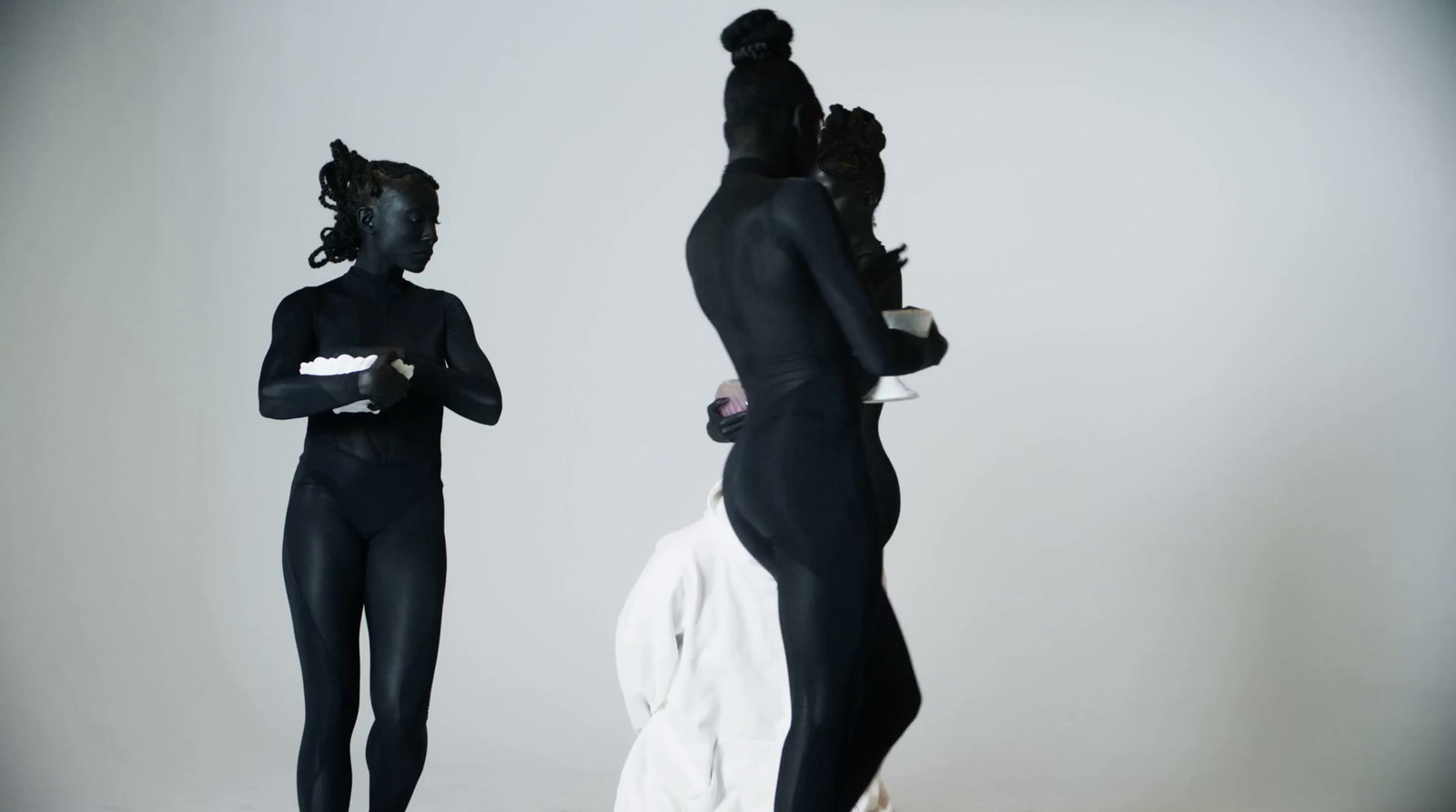 two women in black bodysuits standing next to each other