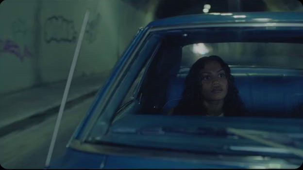 a woman sitting in a blue car in a tunnel