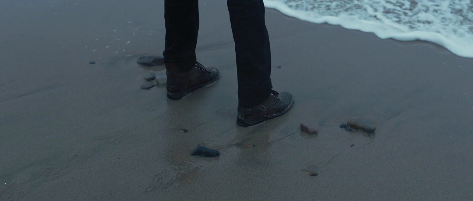 a person standing on a beach next to the ocean