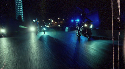 a man riding a motorcycle down a street at night