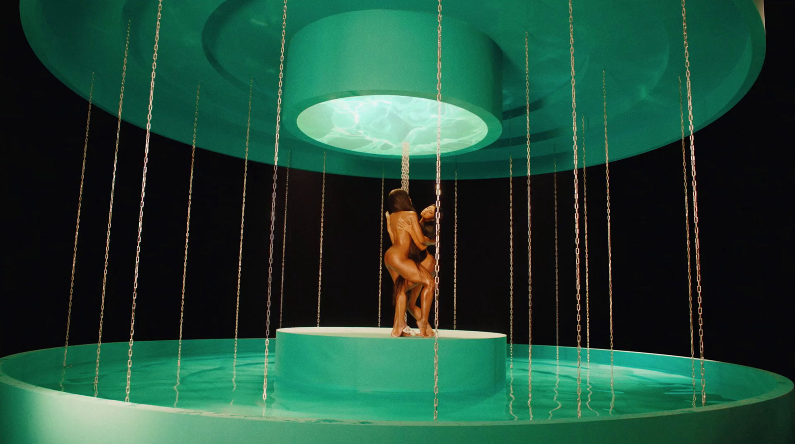 a woman standing on a platform in front of a fountain