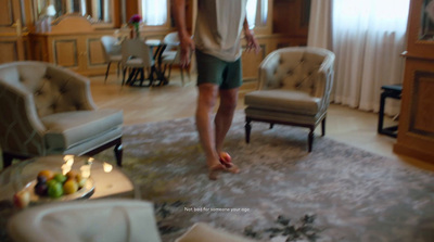 a man standing in a living room next to a chair