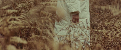 a woman standing in a field of tall grass