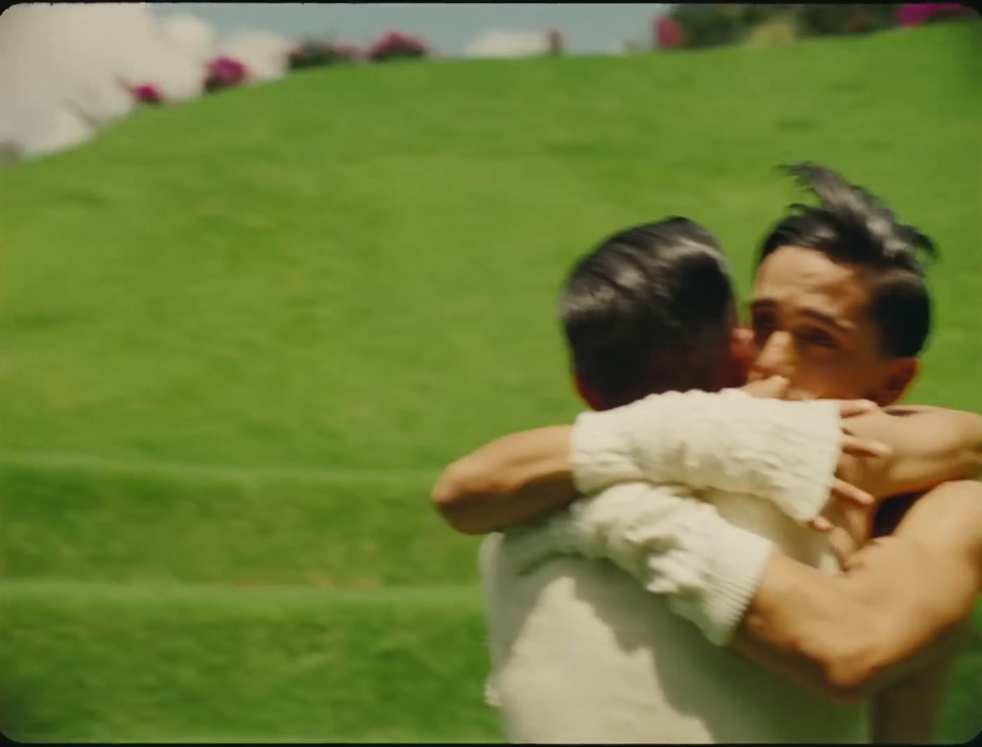 a man hugging another man in a field